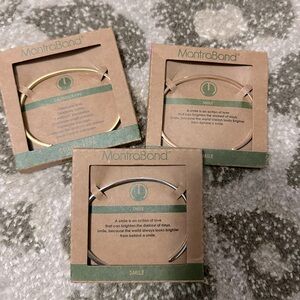 NWT set of three Mantraband slim cuff bracelets - two gold tone one silver